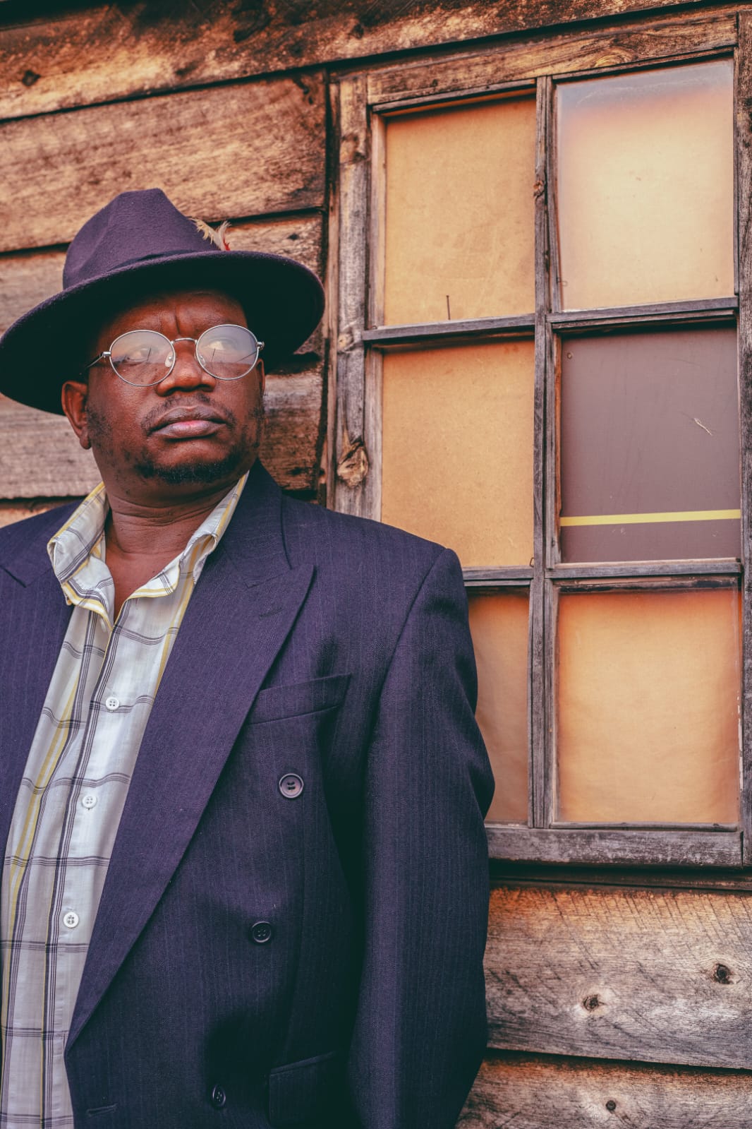 Sifiso Khanyile against a weathered wooden wall